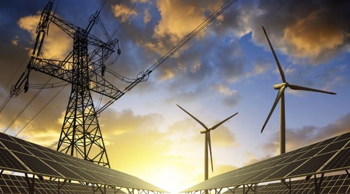 Solar-panels-with-wind-turbines-and-electricity-pylon-at-sunset-000079839049_Medium